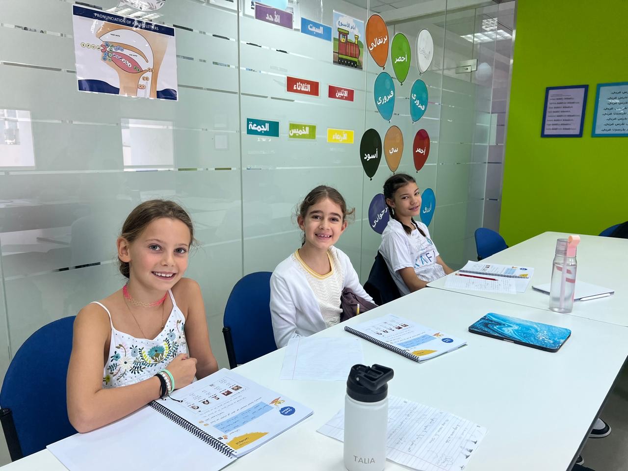 Children working with Arabic workbooks in a classroom